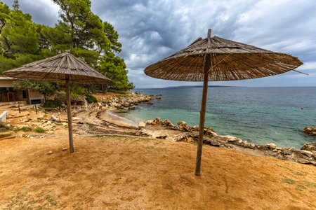 Tara Beach on the island of Rab, Straw sun umbrellas on the shore of the Adriatic Sea, Croatiaの写真素材