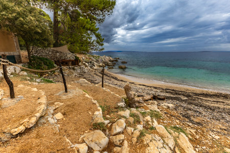 Tara Beach on the island of Rab, Straw sun umbrellas on the shore of the Adriatic Sea, Croatiaの写真素材
