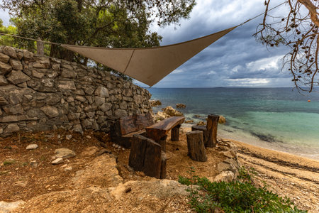 Tara Beach on the island of Rab, Straw sun umbrellas on the shore of the Adriatic Sea, Croatiaの写真素材