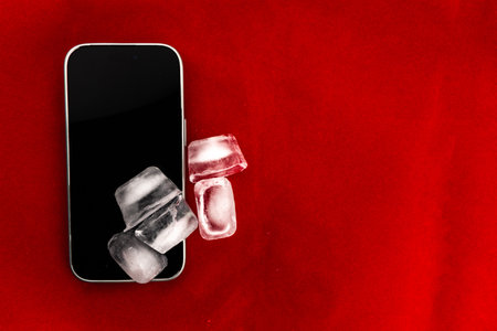 The concept of overheating and fire hazard. Cooling the latest smartphone with ice cubes. Excessive...