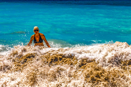 A woman among the high, churning waves of the Atlantic Ocean, Playa del Duque Costa Adeje, Tenerife...