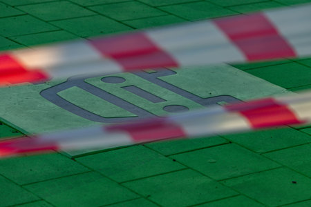 Green-painted parking spot designated for electric vehicles with EV and charging symbol on the pavement. Concept of sustainable transport, eco mobility, and modern city infrastructure.の写真素材