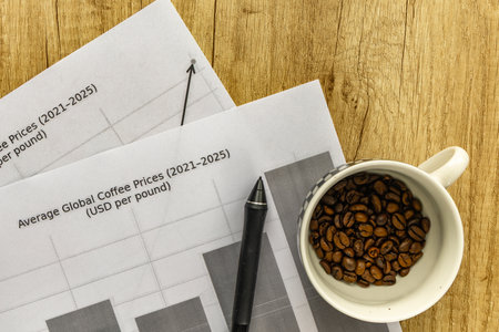 Cup filled with coffee beans placed on printed market charts showing rising global coffee prices. Concept of coffee trade, business growth, and global market trends World. Rising Global Coffee Prices Concept with Cup of Coffee Beans and Market Chartsの写真素材