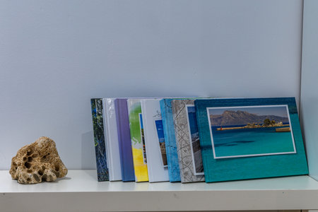 Vacation photo albums arranged on a white table in the guest room, vacation souvenirs, a stone