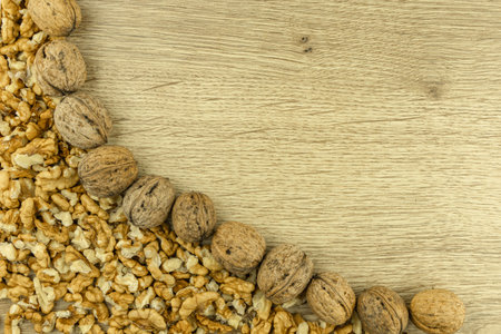 Shelled and peeled walnuts scattered on a wooden table,