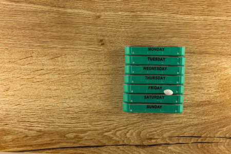 Prescription medications, white pills scattered on the table, arranging medications in the medication container by day of the weekの写真素材