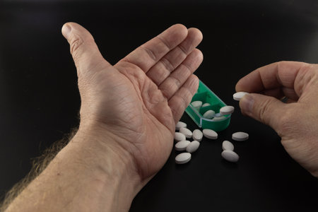 Doctors prescription pills in man's hands, pill counting, painkiller addiction, prescription drugs