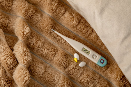A thermometer showing a high temperature of a sick patient, home remedies for colds, an electronic...