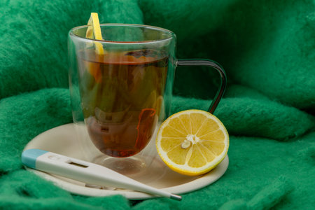 For fever, next to a glass of hot tea with honey and lemon, cold, realistic photo