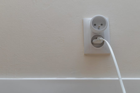 Plug plugged into an electrical outlet, smart electrical outlet, electrical outlet on a white wall...