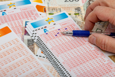 A man crosses out 6 digits on a ticket with a pen, lucky numbers and a big cash win in the lottery....