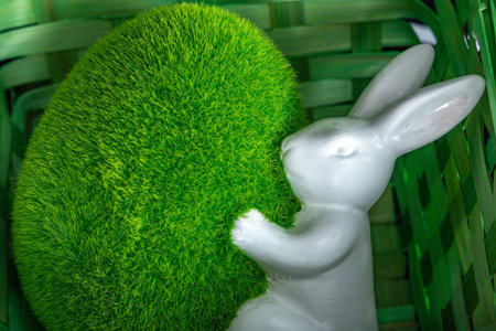 Figurine of a little rabbit and hare in a green basket, Christmas ornaments, Easter decorations, on...