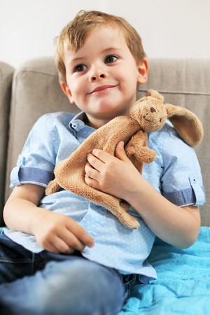 A young toddler smilling with his plush toyの写真素材