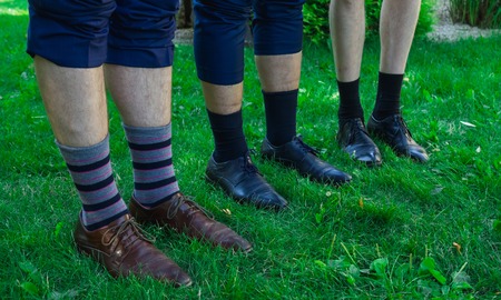 Men's feet in shoes with socks on green grassの写真素材