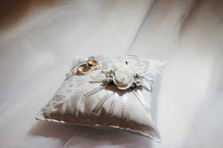 Wedding gold rings, on gift white pillowの写真素材