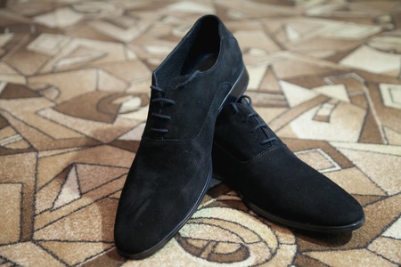 Shiny black men's shoes for the bride lying on the floorの写真素材