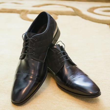 Shiny black men's shoes for the bride lying on the floorの写真素材