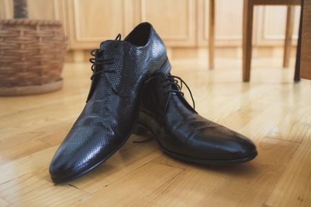 Shiny black men's shoes for the bride, lying on the floorの写真素材