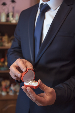 Golden wedding rings, in groom's hands, for the brideの写真素材