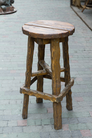 Old wooden stool, standing on a stone roadの写真素材