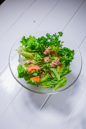 Salad with meat, chicken, lettuce, dill, tomato on white wood background. For the menu restaurant bar cafeの写真素材