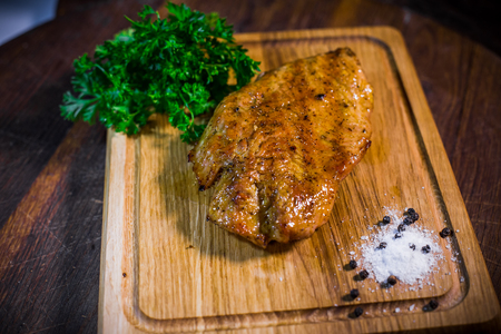 Grilled chicken fillets on wood plate. Wood background.の写真素材