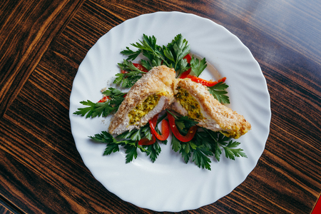 Chicken Kiev on croutons with mashed potatoes, on wooden table, on bright backgroundの写真素材