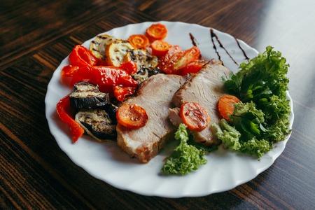 Grilled pork and pumpkin on a grill pan. Vertical view from aboveの写真素材