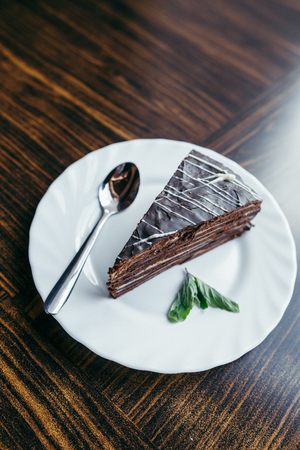 Slice of cake with chopped nuts on wooden chopping boardの写真素材