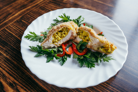 Chicken Kiev on croutons with mashed potatoes, on wooden table, on bright backgroundの写真素材