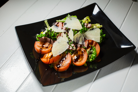 Veal steak salad with arugula, lettuce, tomato, olives and parmesan cheese on white wood backgroundの写真素材