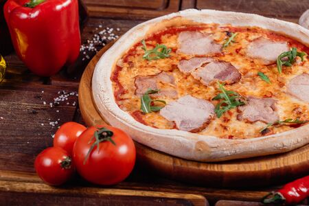 Appetizing Pizza with sliced vegetables on rustic wood, vintage styleの写真素材
