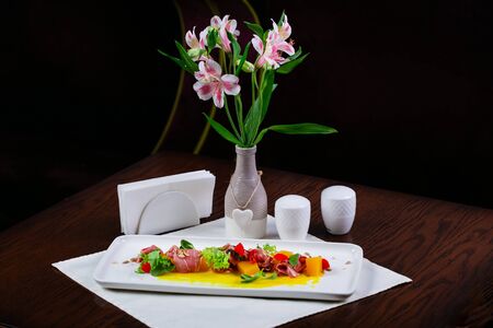 Pumpkin and gravy salad with Spanish jamon, pepper, herbs on a white plate decorated with seedsの写真素材