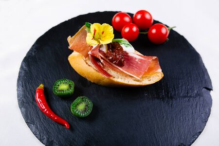 Spanish food tapas. Toasted bread with goat cheese and serrano hamの写真素材