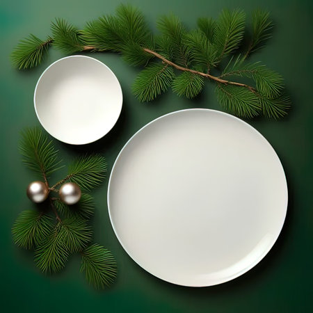 Christmas table setting with empty plates and spruce branches on green backgroundの写真素材