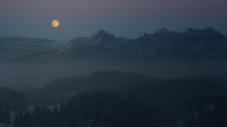 Full moon over the mountains in the winter at dusk. Panoramaの写真素材