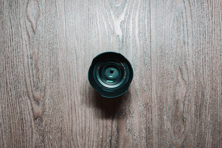 Camera lens on wooden background. Top view. Copy space for text.の写真素材