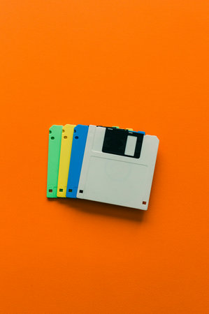 Vintage magnetic floppy disk on orange background. Minimal concept.の写真素材