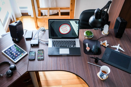 High angle view of a desk with a laptop and a cup of teaの写真素材