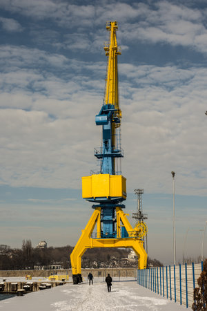 port crane in the winter on a background of blue sky with clouds