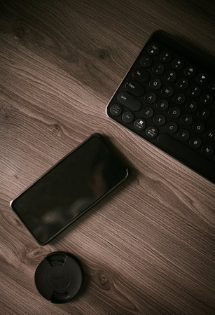 Smartphone and computer keyboard on a wooden background. Toned.の写真素材