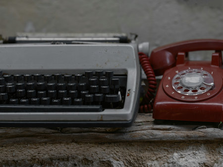 Vintage telephone and old typewriter on the wall, stock photoの写真素材