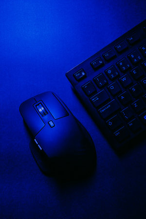 Computer mouse and keyboard on a dark blue background. Toned.の写真素材