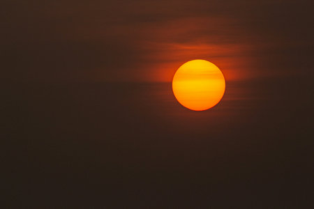 Sunset in the evening sky. The sun sets behind the clouds.