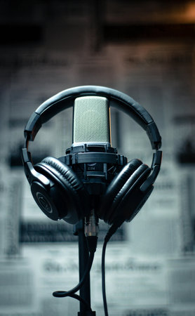 Microphone and headphones on a stand in a recording studio, close-up