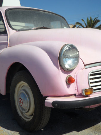 Pink retro car parked on the street.の写真素材