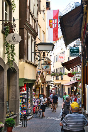 Tourists walk along a narrow street in Salzburg, Austria. Salzburg is the capital and largest city of Austria.の写真素材