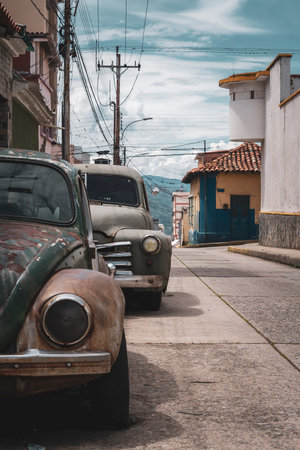 Old cars parked in the street of the old town of Trinidad, Cuba.の写真素材