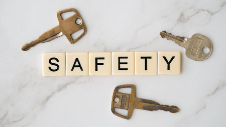 Safety word made of wooden blocks on white marble background with keys.の写真素材