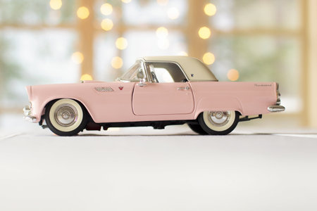 vintage toy car on white table with bokeh lights background